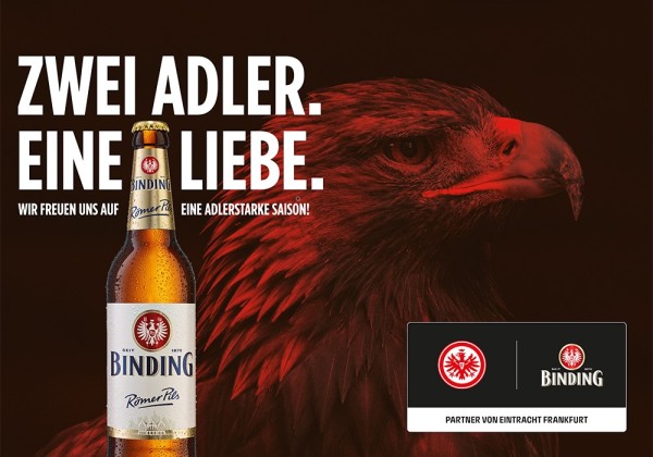 Eine Bierflasche steht neben dem Kopf eines Adlers in einem dunkelroten Hintergrund.