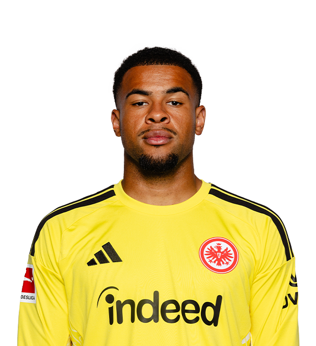 Mann mit kurzen dunklen Haaren und kurzem Kinnbart trägt ein leuchtend gelbes Eintracht Frankfurt Torwarttrikot.