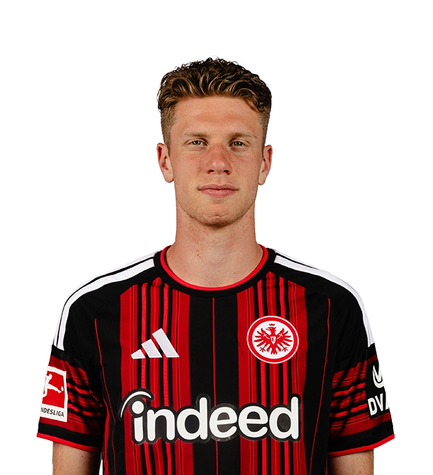 Mann im Eintracht Frankfurt Trikot mit ernstem Gesichtsausdruck. Er hat kurze, dunkle Haare.