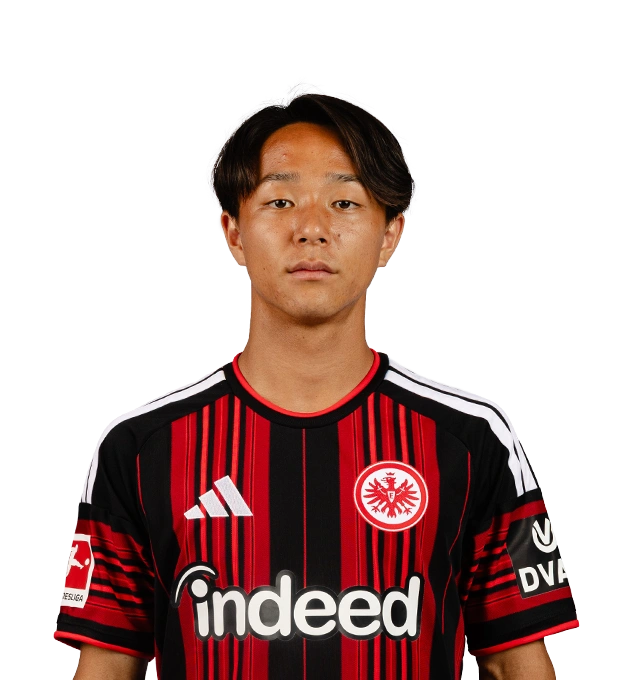 Ein Mann mit mittellangen dunklen Haaren und Mittelscheitel blickt frontal im Eintracht Frankfurt Trikot nach vorn.