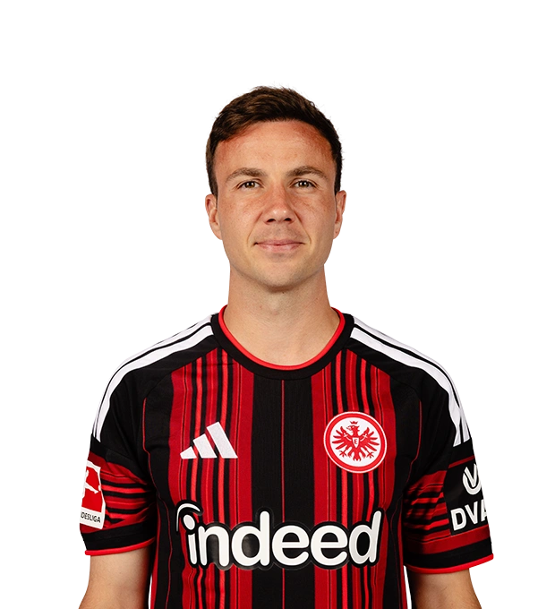 Mit kurzen braunen Haaren und leichtem Lächeln blickt ein Mann im Eintracht Frankfurt Trikot frontal in die Kamera.