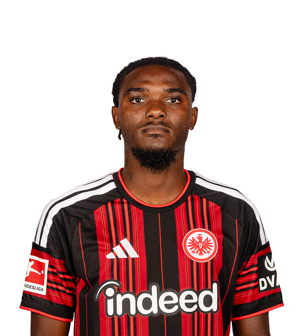 Ein Mann mit zurückgebundenem Haar lächelt in die Kamera. Er trägt ein Eintracht Frankfurt Fußballtrikot.