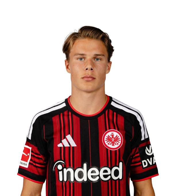 Mit zurückgekämmten blonden Haaren und blauen Augen blickt ein Mann im Eintracht Frankfurt Trikot frontal nach vorn.