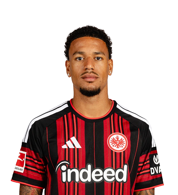 Mann mit kurzen schwarzen Locken, Schnurrbart, Kinnbart und Ohrsteckern trägt ein Eintracht Frankfurt Trikot.