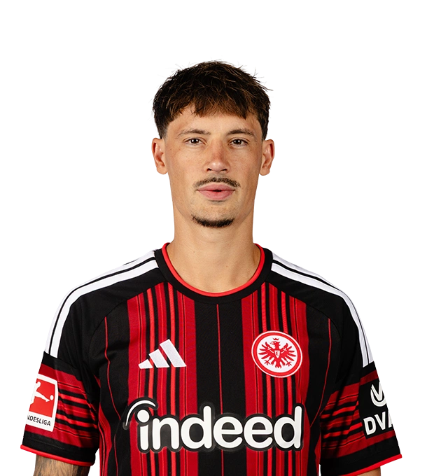 Mann mit kurzem, dunklem Haar und Bart trägt ein Eintracht Frankfurt Fußballtrikot. Sein Gesichtsausdruck ist neutral.