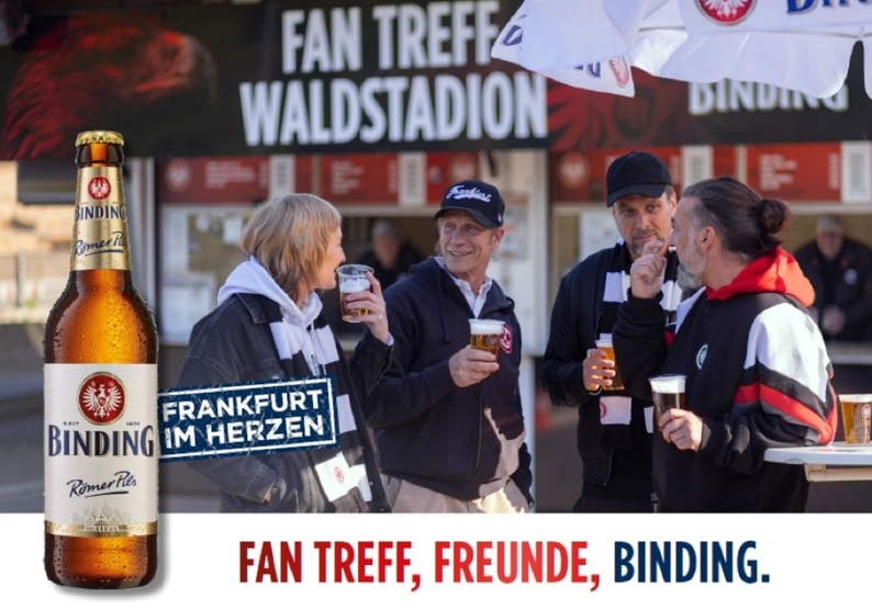 Vor dem Fan Treff Waldstadion stehen vier Eintrach Frankfurt Fans mit Binding Bier.